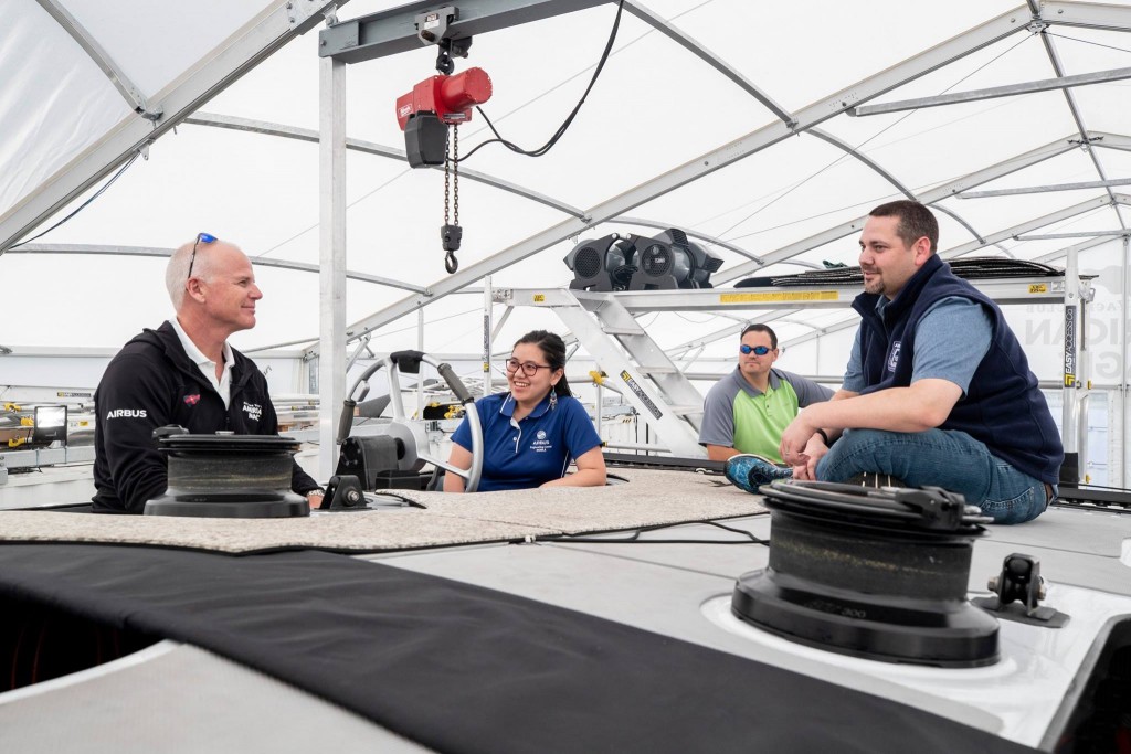 L to R: Terry Hutchinson shows Seng-Ai Liaw, Joshua Powell and Josh Cochran some of the steering techniques of the flying boat.